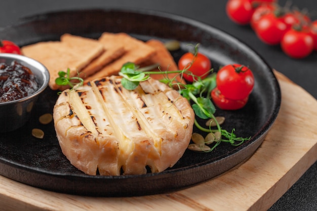 Foto aperitivo caliente al horno camembert o queso brie con mermelada