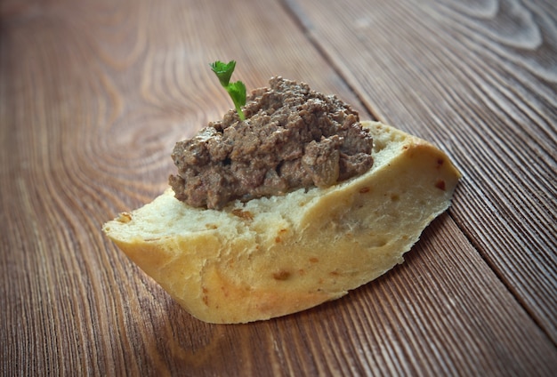 Aperitivo de carne casera paté de hígado de pollo con pan sobre mesa de madera