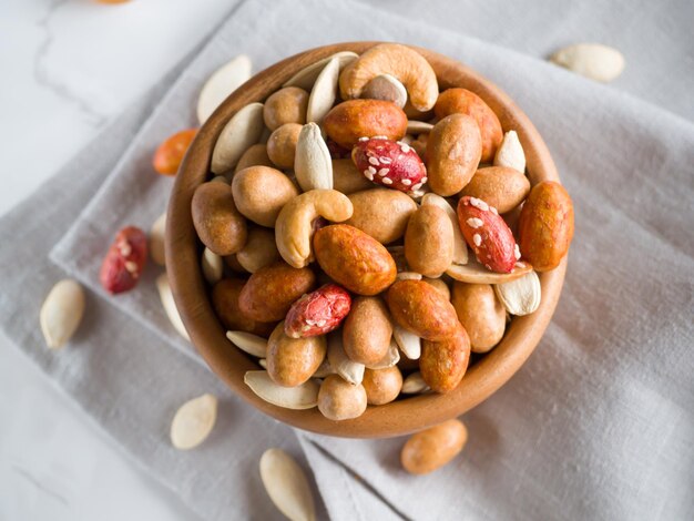 Foto aperitivo para cerveza crujiente variedad de nueces mixtas con diferentes sabores y semillas de calabaza en el arco de madera