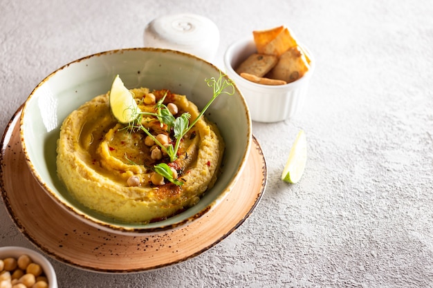 Aperitivo clássico de homus saudável decorado com verduras e temperos