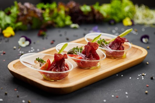 Aperitivo de fatias de presunto seco curado em um fundo escuro Foto para menu de restaurante