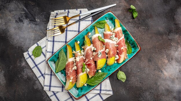 Aperitivo de pêra com jamon, presunto e queijo azul. antipasto italiano. banner, menu, local de receita para texto, vista superior.