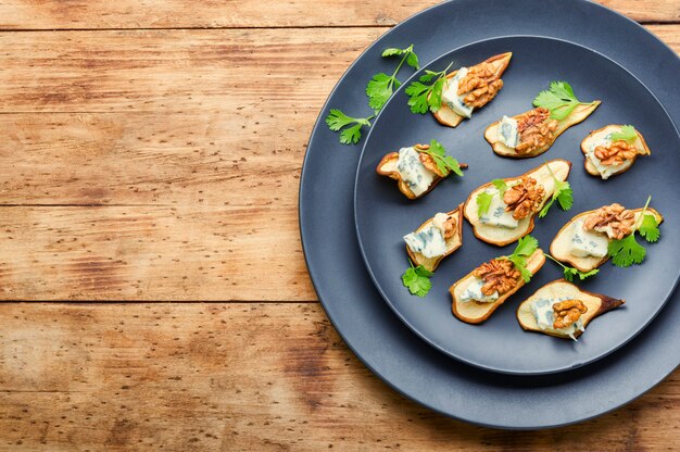 Aperitivo de pera seca, queijo azul e noz. Espaço para texto