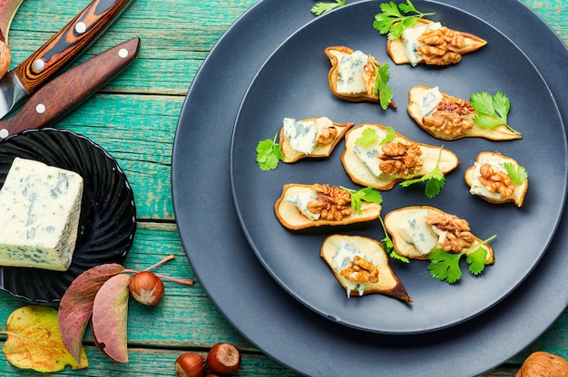 Aperitivo de pera seca, queijo azul e nozes. Pedaços de pêra seca picada