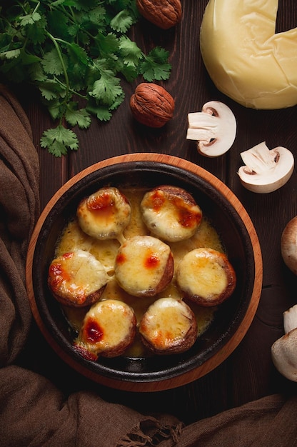 Aperitivo de prato georgiano tradicional cogumelos recheados Queijo Sulguni assado em uma panela de barro Ketzi em uma mesa de madeira fechada sem pes