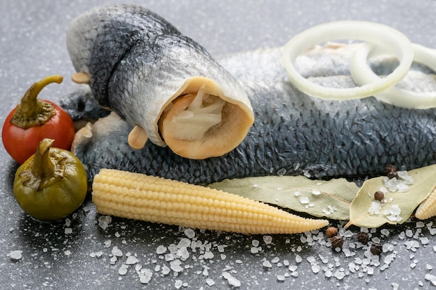 Aperitivo frío de pescado marinado en agua salada Filete de arenque marinado en una tabla de cortar negra