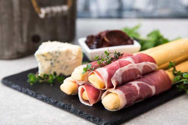 Foto aperitivo con jamón, jamón, queso azul y tomates secos para las fiestas.