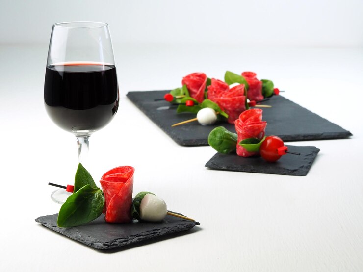 Foto aperitivo lindamente servido em espetos e um copo de vinho tinto