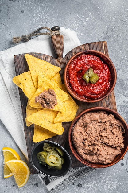 Aperitivo mexicano chips de milho nachos com molho de tomate de carne picada frita e jalapeno Fundo cinza Vista superior