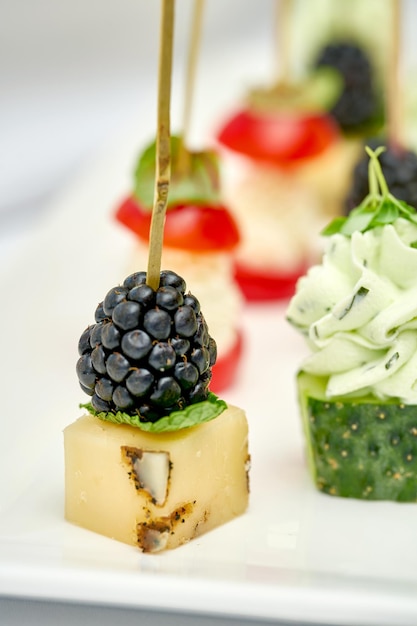 Aperitivo para o banquete queijo duro com morangos em pauzinhos