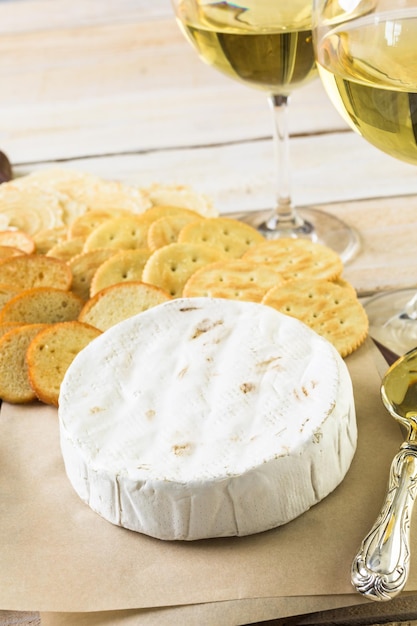 Foto aperitivo de queso brie y galleta para mesa de fiesta.