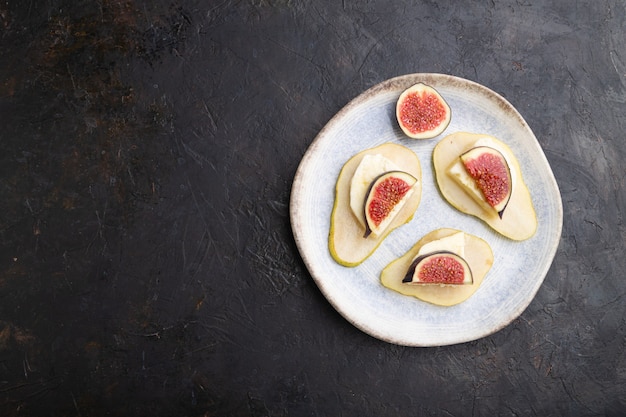 Aperitivo de verano con pera, requesón, higos y miel en plato de cerámica