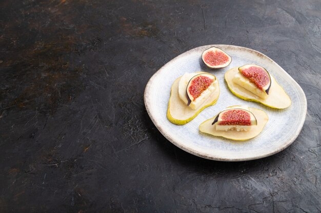 Aperitivo de verano con pera, requesón, higos y miel en plato de cerámica