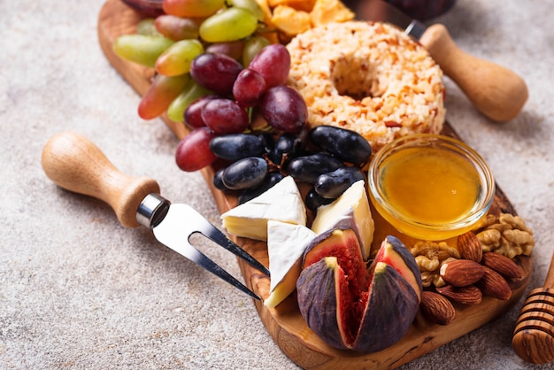 Aperitivo para vino, plato de queso con uvas e higos.