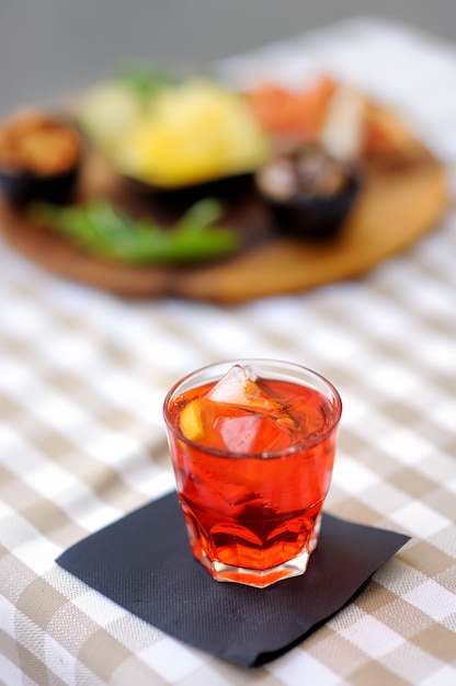 Aperitivos / aperitivos italianos: copa de cóctel (vino espumoso con Aperol) y plato de aperitivos en la mesa