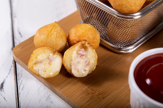 Foto aperitivos brasileños bolas fritas rellenas de jamón y queso enfoque selectivo