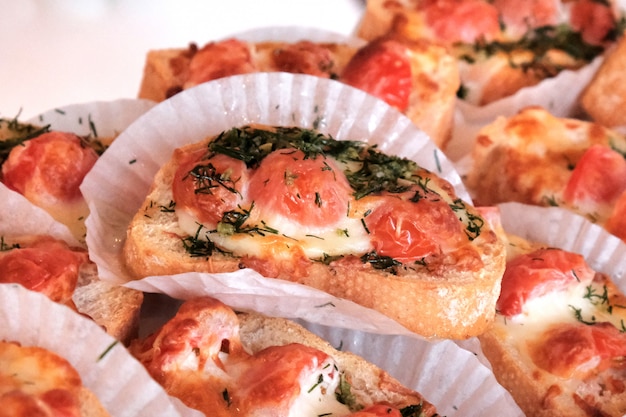 Aperitivos bruschetta con tomate y queso en una mesa de banquete.