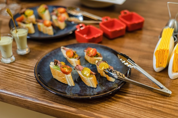 Aperitivos de carne en pan francés con tomate y lechuga Exhibidos en una hermosa mesa de madera