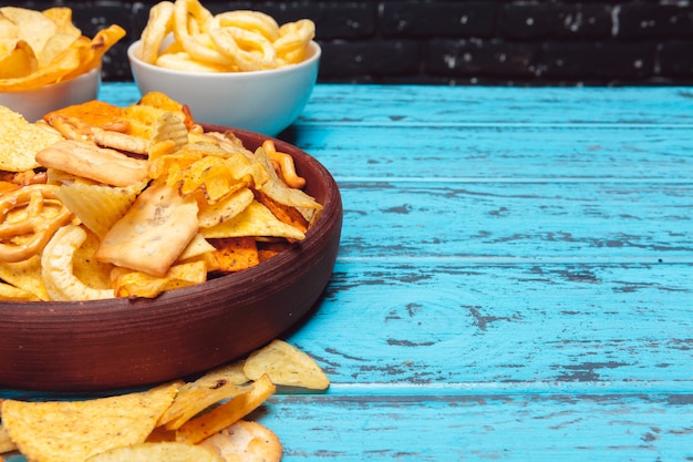 Aperitivos de cerveza como galletas, papas fritas, galletas en una superficie de madera