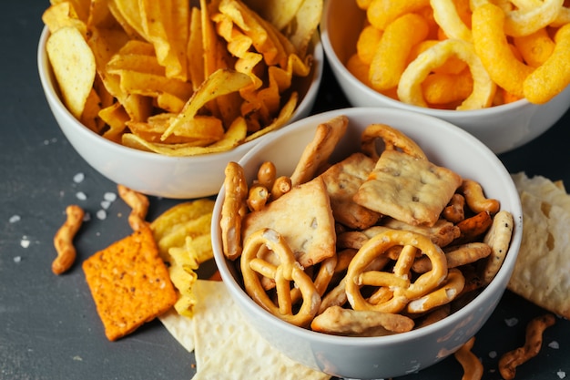 Aperitivos de cerveza en la mesa de piedra. Varias galletas, papas fritas. Vista superior