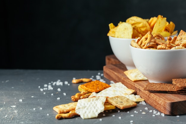 Aperitivos de cerveza en la mesa de piedra. Varias galletas, papas fritas. Vista superior