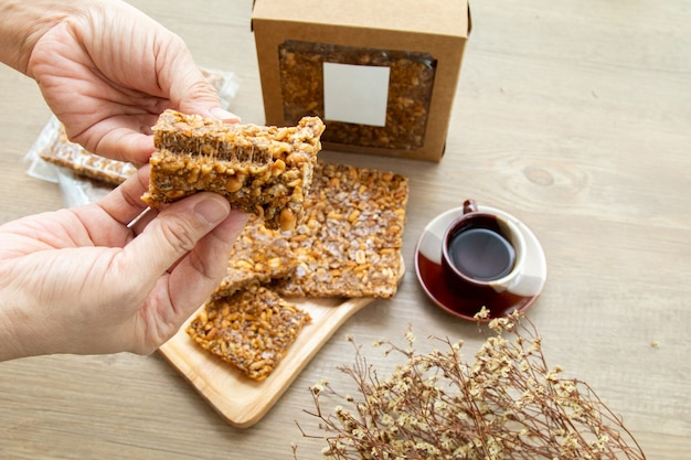 Aperitivos dulces asiáticos, sabrosos frutos secos mixtos y caramelo sobre fondo de madera con luz natural