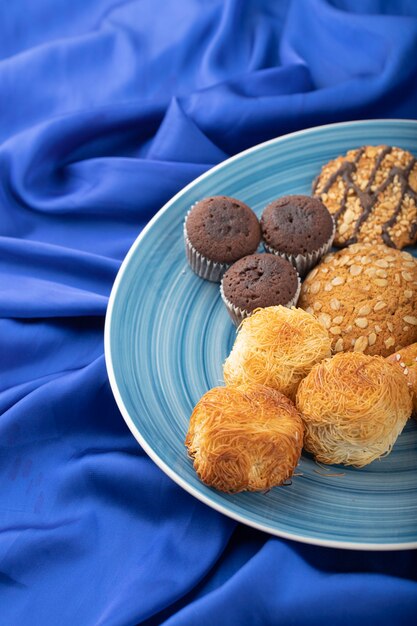 Aperitivos dulces colocados sobre un mantel azul.