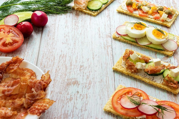 Aperitivos listos con comida correcta con ingredientes sobre un fondo claro de madera con lugar para texto