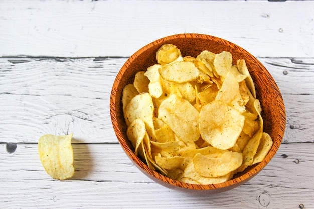 Aperitivos de papas fritas o patatas fritas en un tazón de madera con fondo de madera Pila de papas fritas