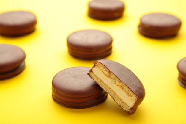 Aperitivos recubiertos de chocolate Choco pie sobre fondo amarillo con espacio de copia.