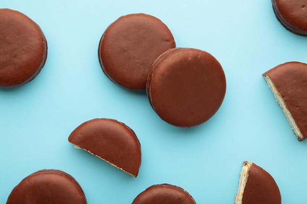 Aperitivos recubiertos de chocolate Choco pie sobre fondo azul con espacio de copia.