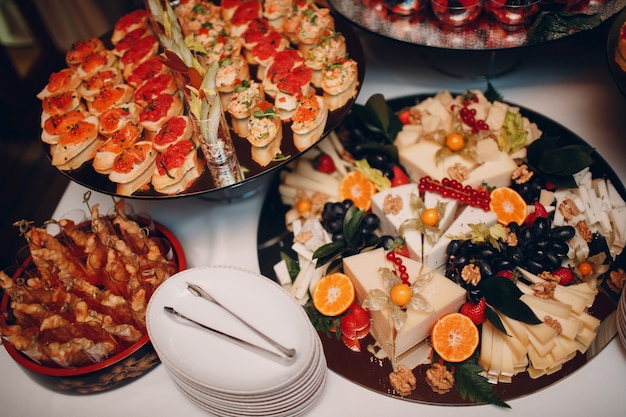 Foto aperitivos sándwiches bruschetta con verduras de pescado y queso en la mesa catering