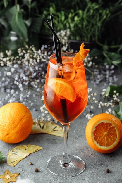 Aperol Spritz Cocktail auf einem grauen Betontisch. ein Glas Aperol Spritz mit Orangenscheiben. Sommercocktail im Glas.