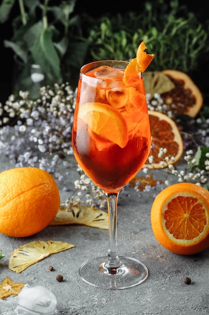 Aperol Spritz Cocktail auf einem grauen Betontisch. ein Glas Aperol Spritz mit Orangenscheiben. Sommercocktail im Glas.