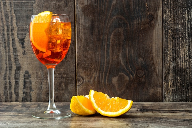 Foto aperol spritz cocktail em vidro no espaço da cópia de mesa de madeira