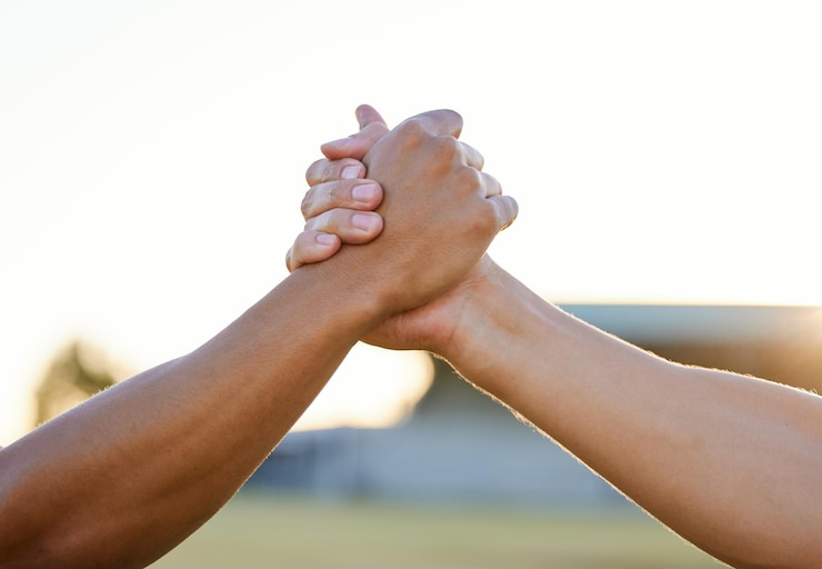 Foto apertar as mãos do parque e das pessoas para apoio, acordo e colaboração ao ar livre amigos, trabalho em equipe e close-up de gesto de saudação para amizade, comunidade e solidariedade no fundo do céu