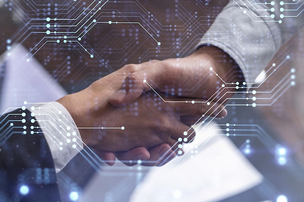 Foto aperto de mão de dois empresários como conceito de acordo para desenvolver um novo software para melhorar o serviço em uma empresa ícones tecnológicos mulher no negócio