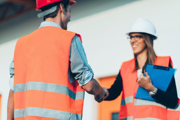 Aperto de mão de negócios no canteiro de obras