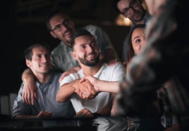 Aperto de mão funcionários felizes na mesa do escritório