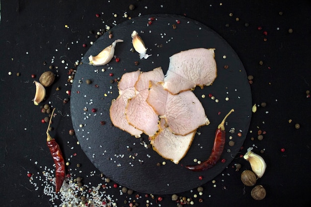 Apetitosa carne en rodajas al horno en tablero de pizarra y primer plano de fondo de lino