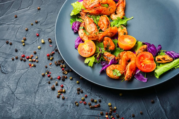 Apetitosa ensalada brillante con camarones, tomate y lechuga en un plato.