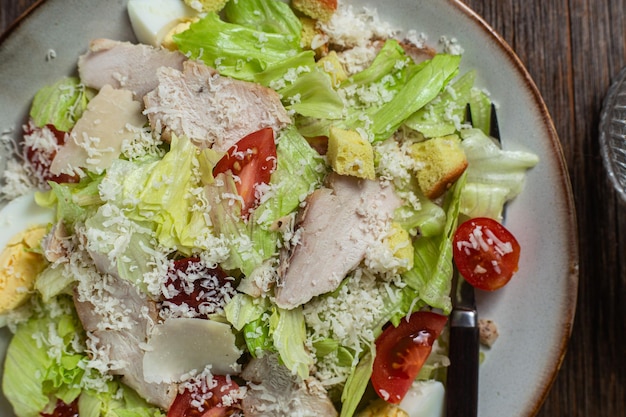 Foto apetitosa ensalada césar en un plato sobre una mesa de madera