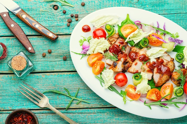 Apetitosa ensalada con tomate, pepino, lechuga y filete de carne. Filete a la parrilla en rodajas