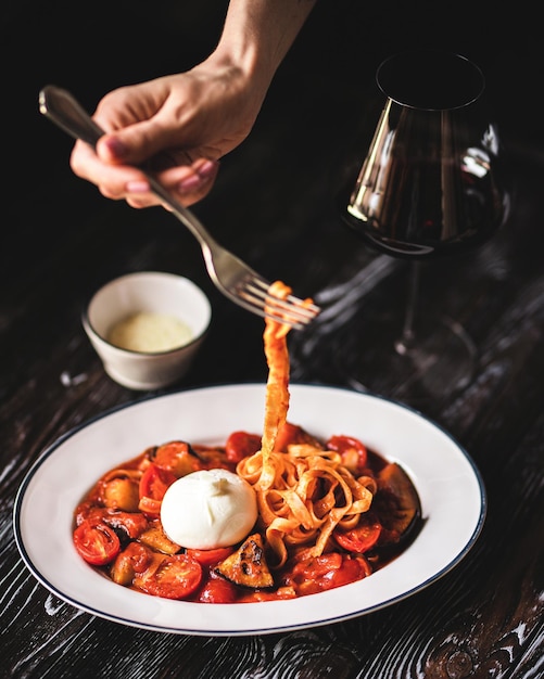 Apetitosa pasta italiana con queso sobre un fondo de madera oscura