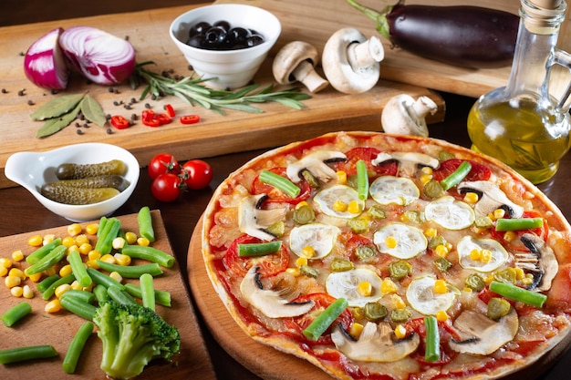 Apetitosa pizza em uma mesa escura com ingredientes