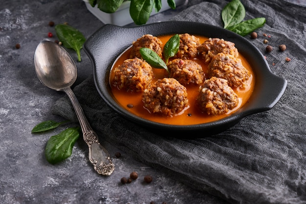 Apetitosas albóndigas caseras con salsa de tomate y espinacas en un plato