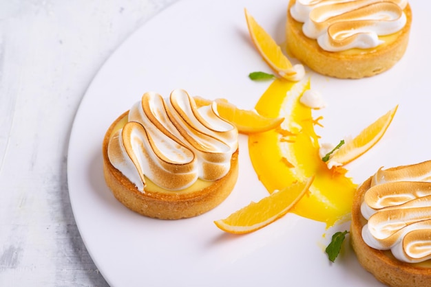 Apetitosas tartaletas de limón con merengue servidas en un plato blanco