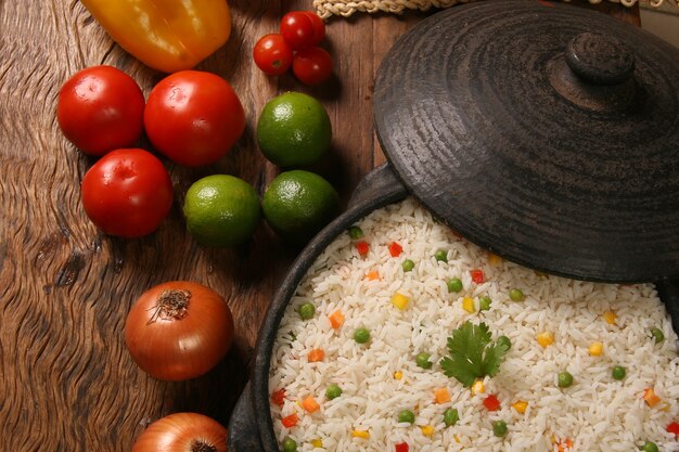 Apetitoso arroz saludable con verduras en plato blanco sobre una mesa de madera. color arroz