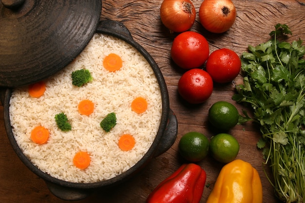 Apetitoso arroz saludable con verduras en plato blanco sobre una mesa de madera. color arroz