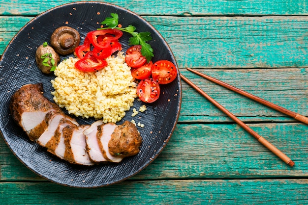 Apetitoso bistec de carne con gachas de bulgur y verduras